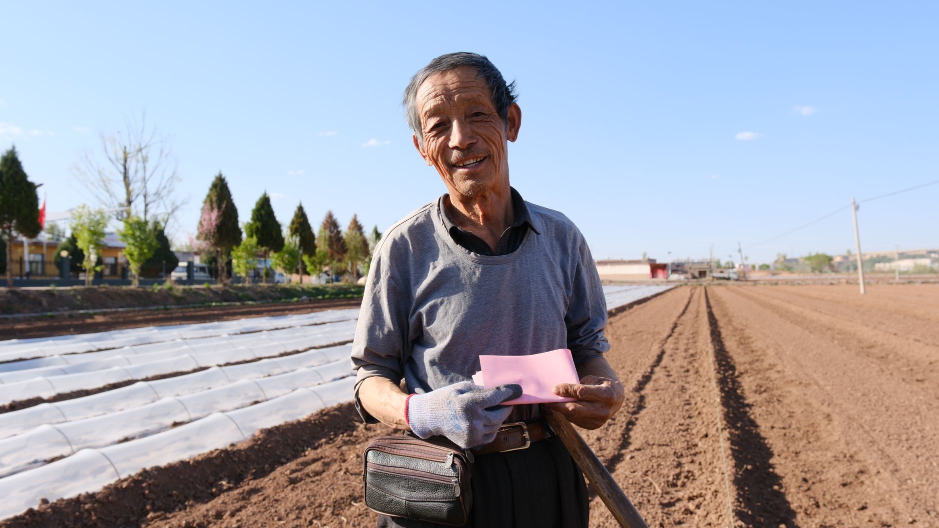 농지를 바라보며 서류를 살펴보는 중년 부부